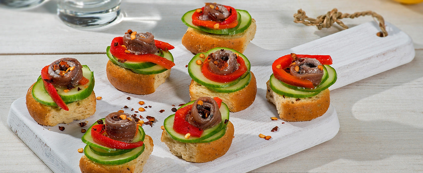 Oregano rusks with cucumber, Florinis pepper and sardines 7-10 “the Manna” small wheat rusks with oregano 1 cucumber, 1 Florinis pepper, Sardines (1 sardine fillet per rusk), Red wine vinegar, ½ lemon, Salt, Pepper